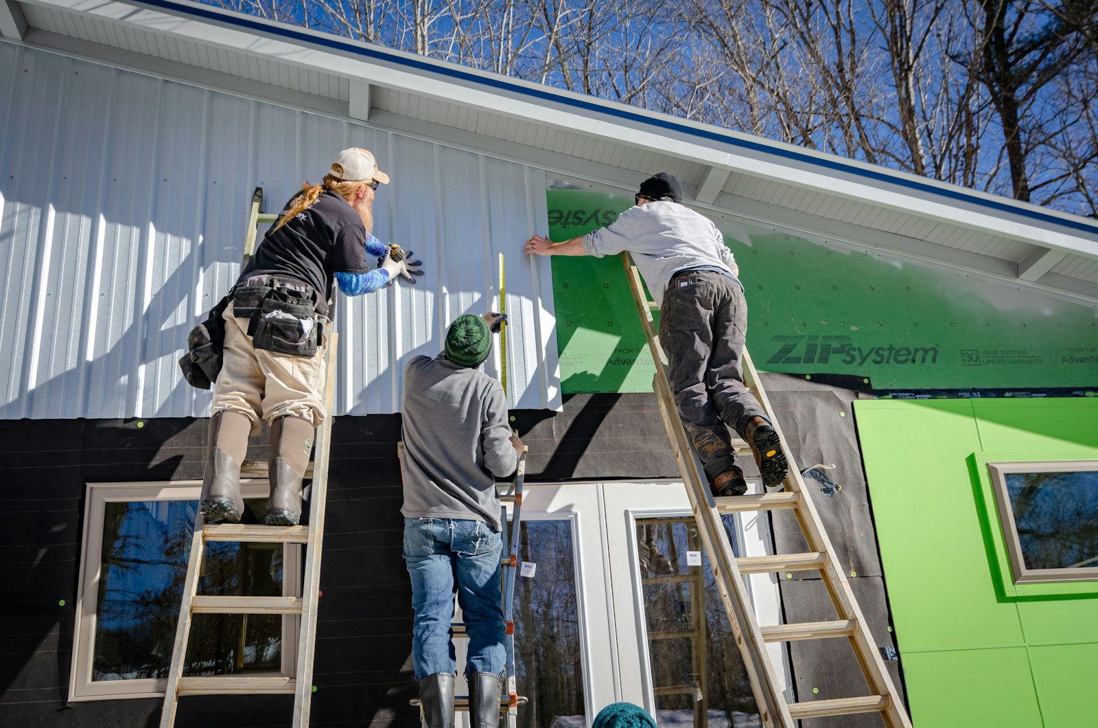 Photo by Jens Behrmann three person climbing on ladder